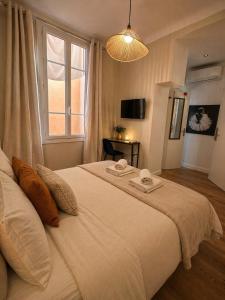 a bedroom with a large white bed with a window at Chambre Confort Premium - Monaco 1 in Beausoleil