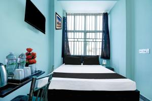 a bedroom with a bed with blue walls and a window at Hotel O Bhubaneshwar Near ITER College in Bhubaneshwar