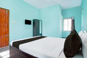 a bedroom with a large bed with blue walls at Hotel O Bhubaneshwar Near ITER College in Bhubaneshwar
