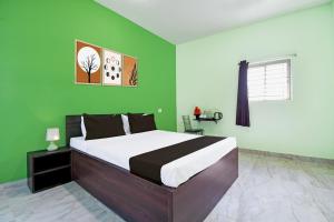 a bedroom with a large bed with green walls at Hotel O Bhubaneshwar Near ITER College in Bhubaneshwar +34 photos