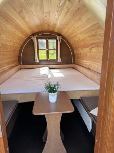 a tiny house with a bed and a table at Campingplatz Weserterrassen Polle in Polle