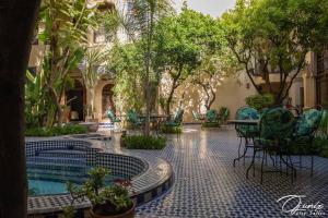 a patio with a table and chairs and trees at Ryad Salama in Fez