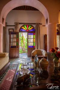 a living room with a table and a stained glass window at Ryad Salama in Fez