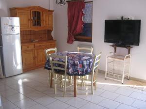 cocina con mesa con sillas y TV en Les Genêts Valderois, en Valderiès