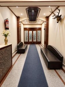 a hallway with two black leather couches and a carpet at Hotel Samar in Srinagar