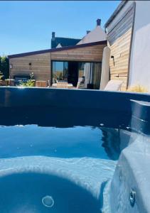 a swimming pool with blue water in front of a house at Gîte grand confort 15 personnes - Le Domaine - Wimereux in Wimereux