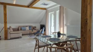 a dining room with a glass table and chairs at Apartamenty Bujowy in Ustroń