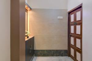 a door leading into a bathroom with a wooden wall at Super Hotel O Howrah Railway Station in Kolkata