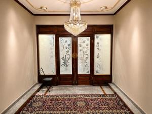 a hallway with a door with a chandelier at Hotel Samar in Srinagar