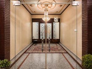 a hallway with a door with a chandelier at Hotel Samar in Srinagar