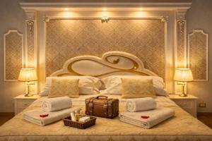 a bedroom with a large bed with towels and a suitcase at Barberini Dream in Rome