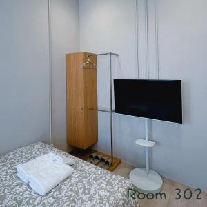 a bedroom with a bed with a flat screen tv at 崗崗好 Gangan House in San-fen-tzu +15 photos