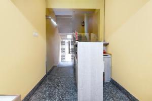 a hallway of a kitchen with a refrigerator in a room at Hotel O Ecopark Kolkata in kolkata
