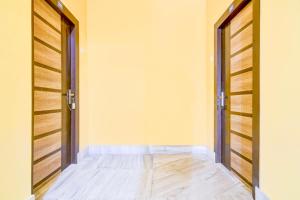an empty room with two doors and wooden floors at Hotel O Ecopark Kolkata in kolkata