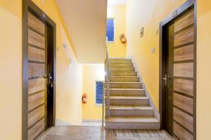 a staircase in a house with wooden doors at Hotel O Ecopark Kolkata in kolkata