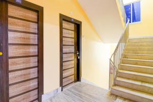 a hallway with two doors and a staircase at Hotel O Ecopark Kolkata in kolkata +36 photos