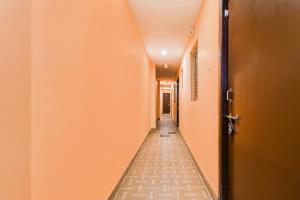 an empty corridor with orange walls and a long hallway at Hotel O Dakshin Dwar Formerly Radha Krishna Niwas in Puri