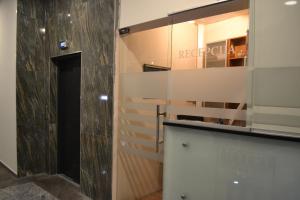 a bathroom with a white wall and a mirror at Hotel Istra in Varaždin