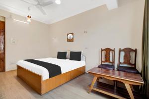 a bedroom with a bed and a wooden table at Super Townhouse Rajbagh Formerly Hotel Modern in Srinagar