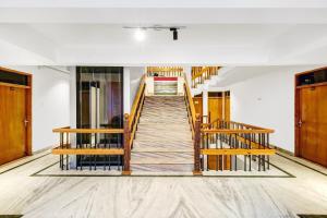 a staircase in an empty room with wooden stairs at Super Townhouse Rajbagh Formerly Hotel Modern in Srinagar