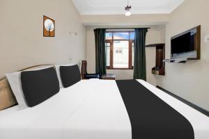 a bedroom with a large bed and a television at Super Townhouse Rajbagh Formerly Hotel Modern in Srinagar +60 photos