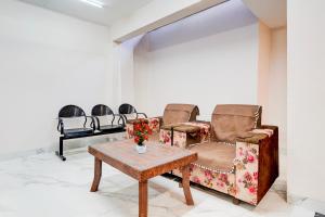 a waiting room with two chairs and a table at Super Collection O Ganeshpuri Indore in Indore