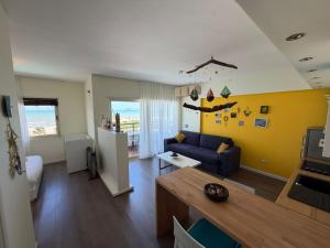 a living room with a blue couch and a yellow wall at ApartHotel by Comfort Suites in Golem