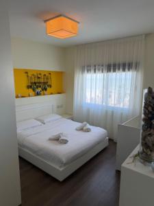 a bedroom with a large white bed and a window at ApartHotel by Comfort Suites in Golem +138 photos
