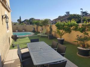 a patio with a table and chairs and a swimming pool at Chez DavSon in Cers