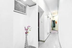 a hallway with a vase with flowers in it at Collection O Karaya Road Formerly Hotel New Diamond in Kolkata