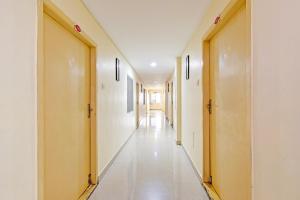 a corridor of a hospital with white walls and white floors at OYO Collection O NAD Near Airport in Visakhapatnam