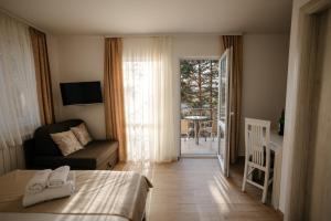 a bedroom with a bed and a couch and a balcony at Markov Konak in Divčibare