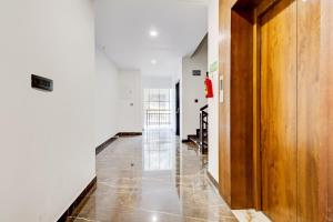 a hallway with white walls and a wooden door at Collection O Munnar in Munnar