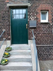 a green door with two bowls of vegetables in front of a building at Gemütliche Ferienwohnung in Bottrop