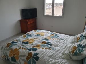 a bedroom with a bed with a floral comforter on it at Chez DavSon in Cers