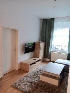 a living room with a couch and a tv at Gemütliche Ferienwohnung in Bottrop