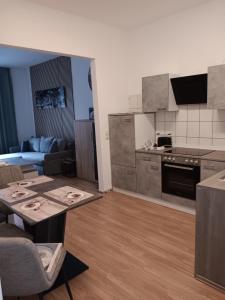 a living room with a table and a kitchen at Gemütliche Ferienwohnung in Bottrop