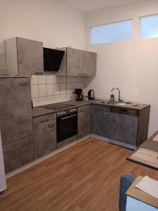 a kitchen with stainless steel appliances and wooden floors at Gemütliche Ferienwohnung in Bottrop +4 photos