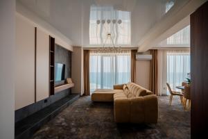a living room with a couch and a television at Noble Hotel by Building Stefan in Mamaia Sat/Năvodari
