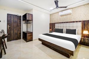 a bedroom with a large bed and a desk at Super Hotel O Vijayawada Near Railway Station in Vijayawāda