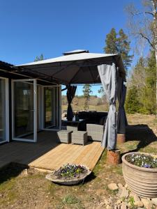 a patio with an umbrella and a couch on a deck at Holiday home Kolmårdsgården in Kolmården