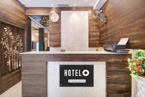 a hotel reception desk with a clock on the wall at Super Hotel O Vijayawada Near Railway Station in Vijayawāda
