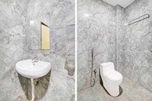 a bathroom with a white toilet and a sink at Super Hotel O Vijayawada Near Railway Station in Vijayawāda
