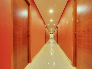 a corridor with orange walls and a long hallway at Super Collection O Bommarilu Warangal in Warangal