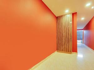 an empty room with orange walls and a glass door at Super Collection O Bommarilu Warangal in Warangal