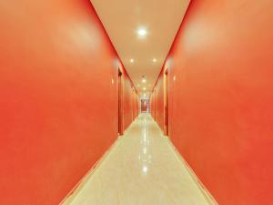a corridor with red walls and a long hallway at Super Collection O Bommarilu Warangal in Warangal +35 photos