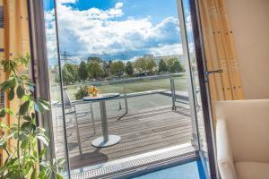 a sliding glass door with a table on a balcony at Tunici Team Hotel in Hamburg