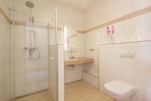 a white bathroom with a shower and a toilet at Tunici Team Hotel in Hamburg