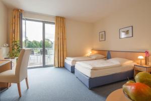 a hotel room with two beds and a balcony at Tunici Team Hotel in Hamburg