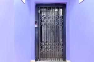a black door with a metal gate on a blue wall at Super Collection O New Town Near OM Sweets Formerly Shiva Inn in kolkata